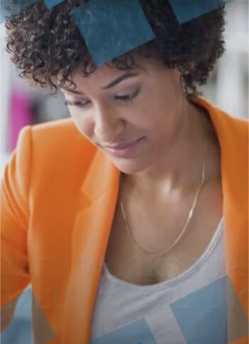 an african american woman wearing an orange suit jacket